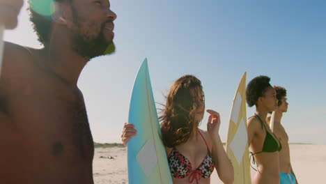 Group-of-happy-friends-standing-with-surfboard-4k