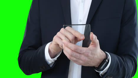 Mid-section-of-a-Caucasian-man-holding-a-transparent-screen-on-green-background