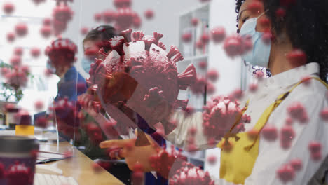 Animation-of-floating-covid-19-cells-with-colleagues-in-office-wearing-face-masks