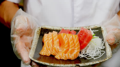 Männlicher-Koch-Hält-Einen-Teller-Mit-Sushi-In-Der-Küche-4k