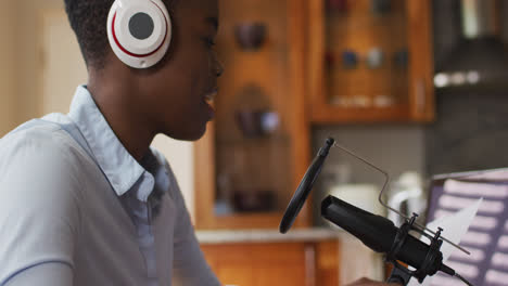 Afroamerikanische-Frau-Mit-Kopfhörern,-Die-Zu-Hause-Im-Mikrofon-Singt