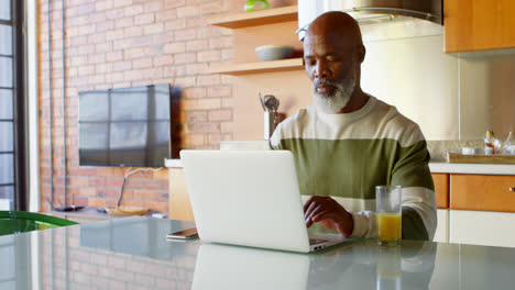 Älterer-Mann-Benutzt-Laptop-In-Der-Küche-Zu-Hause-4K