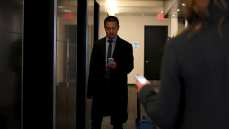 Businessman-using-mobile-phone-near-elevator-in-a-modern-hotel-4k