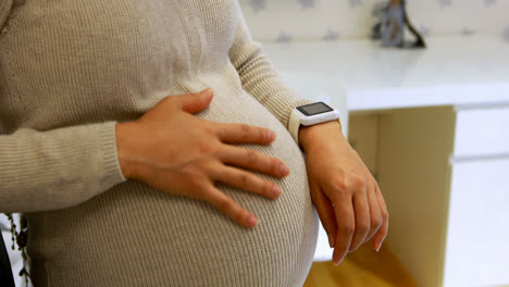 Mid-section-of-pregnant-woman-using-smartwatch-4k