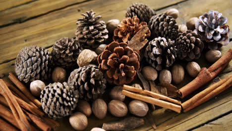 Pine-cones-and-cinnamon-sticks-on-wooden-table-4k
