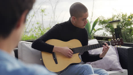 Un-Joven-Caucásico-Tocando-La-Guitarra-En-Una-Azotea.