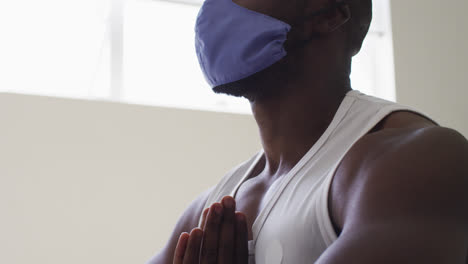 Hombre-Afroamericano-En-Forma-Con-Mascarilla-Practicando-Yoga-En-Un-Estudio-De-Yoga