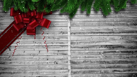 Video-composition-with-snow-over-Christmas-gift--ribbon-on-wood