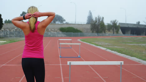 Rear-view-of-Caucasian-female-athlete-walking-on-running-track-4k