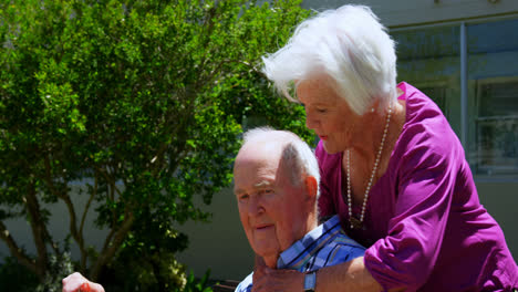 Side-view-of-active-Caucasian-senior-couple-embracing-each-other-in-the-garden-of-nursing-home-4k