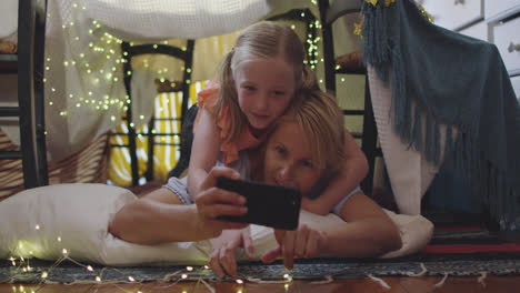Front-view-of-Caucasian-woman-using-her-phone-with-her-daughter-at-home