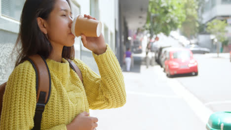 Teenage-girl-drinking-coffee-on-sidewalk-4k