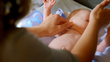 Mother-giving-hand-massage-to-her-baby-boy-at-home-4k