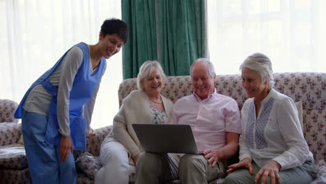 Front-view-of-active-Caucasian-senior-friends-and-female-doctor-using-laptop-in-the-nursing-home-4k