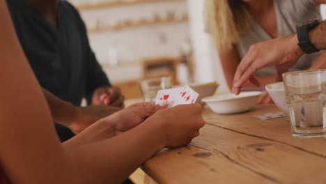 Mittelteil:-Zwei-Paare-An-Einem-Tisch-Beim-Kartenspielen
