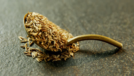 Cumin-seeds-in-spoon-on-concrete-background-4k