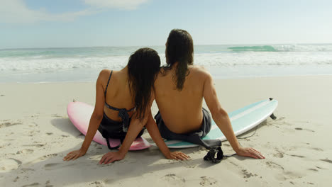 Pareja-De-Surfistas-Sentados-En-La-Playa-Con-Tablas-De-Surf-4k-4k