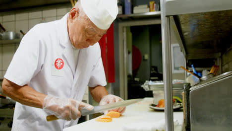 Male-chef-cutting-sushi-in-kitchen-4k