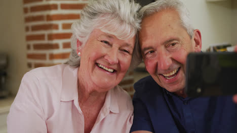 Senior-caucasian-couple-at-home-using-smartphone