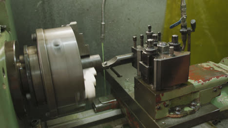 Piece-of-machinery-in-the-workshop-at-a-factory-turning-with-cooling-jet-of-liquid