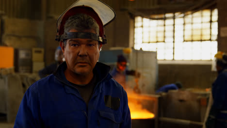 Worker-standing-in-protective-helmet-in-foundry-workshop-4k