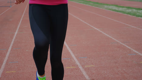 Front-view-of-Caucasian-female-athlete-exercising-on-running-track-at-sports-venue-4k