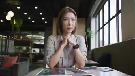 Asiatische-Geschäftsfrau,-Die-Einen-Video-Chat-Führt-Und-Den-Papierkram-Im-Modernen-Büro-Durchgeht