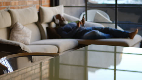 Senior-man-listening-music-on-mobile-phone-in-living-room-4k