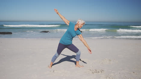 Ältere-Kaukasische-Frau-Praktiziert-Yoga-Am-Strand