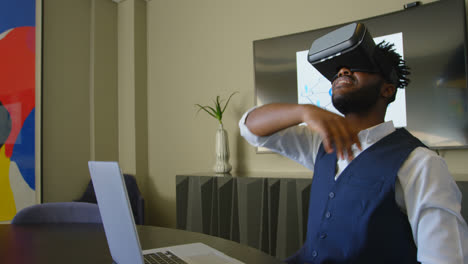 Seitenansicht-Eines-Jungen-Schwarzen-Geschäftsmannes,-Der-Gestikuliert,-Während-Er-Ein-Virtual-Reality-Headset-Im-Büro-Verwendet,-4k