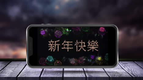 Digital-animation-of-happy-new-year-text-in-chinese-and-fireworks-exploding-on-smartphone