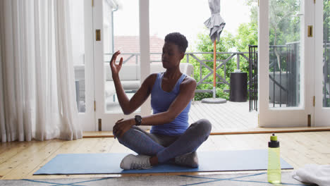 African-american-woman-performing-stretching-exercise-at-home