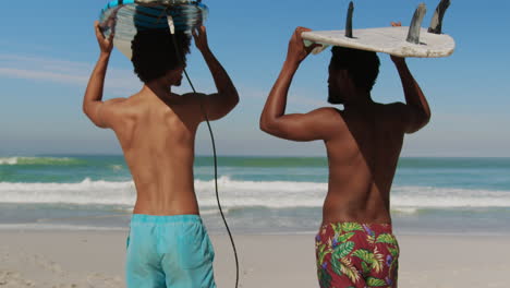 Jóvenes-Amigos-Llevando-Tabla-De-Surf-En-La-Cabeza-4k