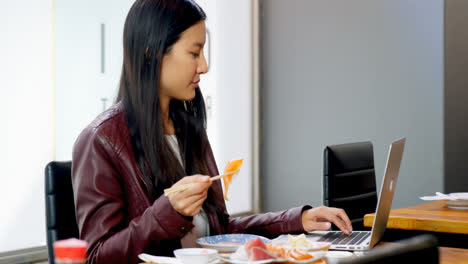 Mujer-Comiendo-Sushi-Mientras-Usa-Una-Computadora-Portátil-En-Un-Restaurante-4k