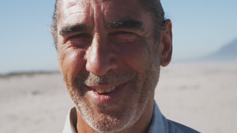 Portrait-of-a-senior-Caucasian-man-enjoying-time-on-the-beach