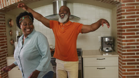 Afroamerikanisches-Seniorenpaar-Tanzt-Zusammen-In-Der-Küche-Zu-Hause
