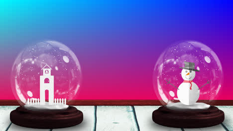 Animation-of-two-snow-globes-with-snowman-and-church-tower-on-gradient-blue-to-pink-background