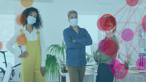 Animation-of-digital-interface-showing-statistics-with-colleagues-in-office-wearing-face-masks