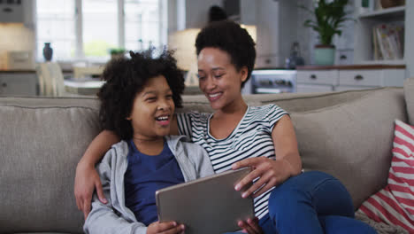 Mixed-race-mother-and-daughter-using-a-digital-tablet