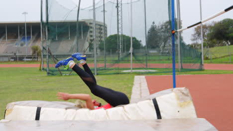 Side-view-of-Caucasian-female-athlete-practicing-high-jump-at-sports-venue-4k
