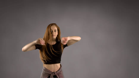 Woman-dancing-against-grey-background