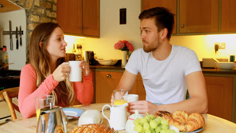 Couple-having-coffee-on-dining-table-in-kitchen-4k