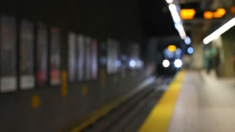 Blurred-commuters-waiting-for-train-on-subway-platform-4k