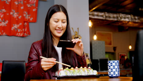 Woman-taking-photo-of-sushi-with-mobile-phone-4k
