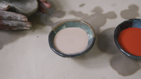 Close-up-view-of-female-potter-working-on-clay-to-create-pot-at-pottery-studio