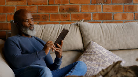 Senior-man-using-digital-tablet-in-living-room-4k