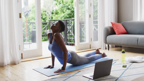 African-american-woman-performing-stretching-exercise-at-home