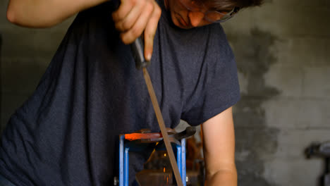 Female-metalsmith-shaping-horseshoe-in-factory-4k