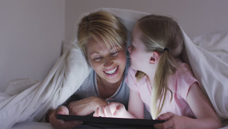 Front-view-of-Caucasian-woman-and-her-daughter-using-digital-tablet-on-bed-
