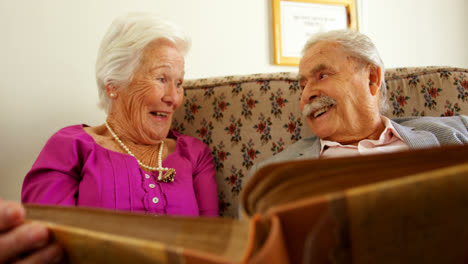 Front-view-of-active-Caucasian-senior-couple-looking-at-photo-album-in-nursing-home-4k